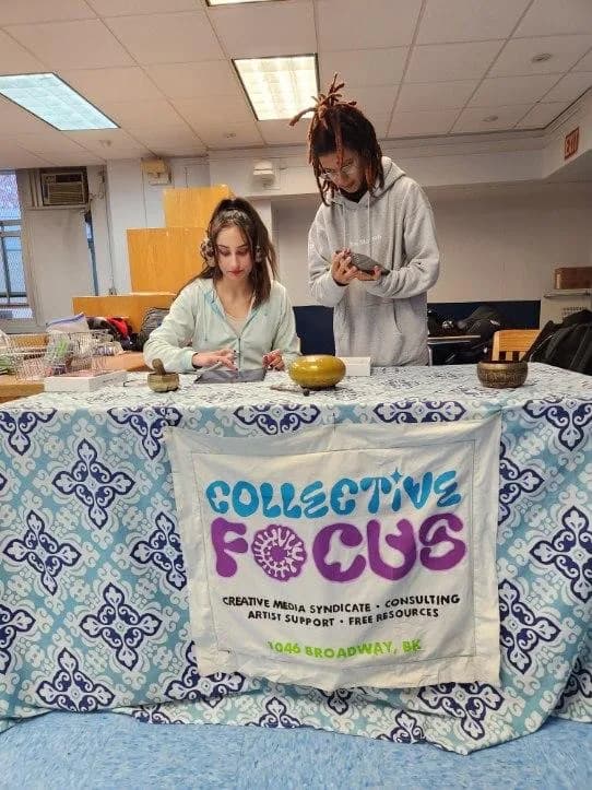 Two adults seated behind a table with a Collective Focus banner.