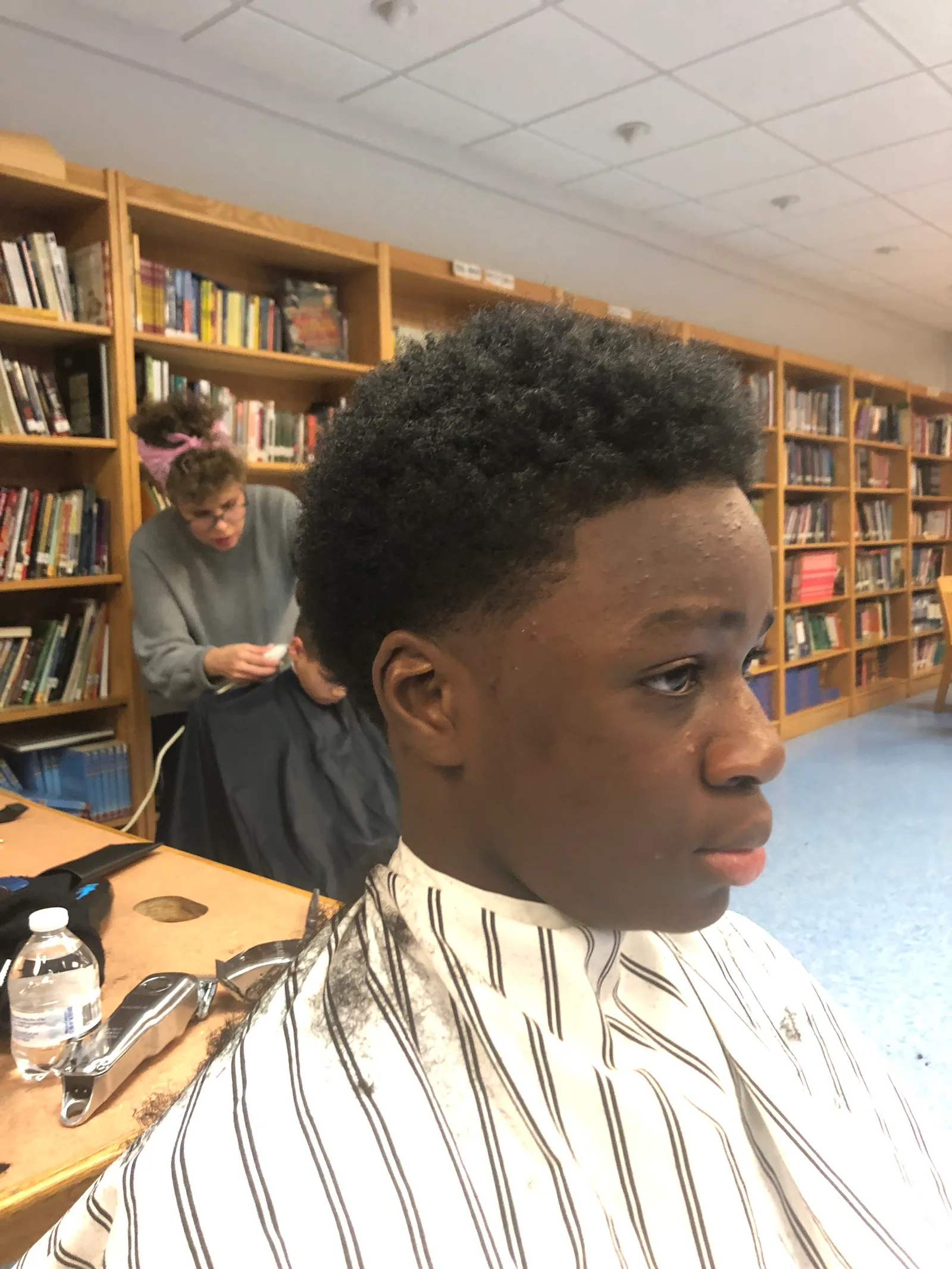 Student shown in profile after a haircut.