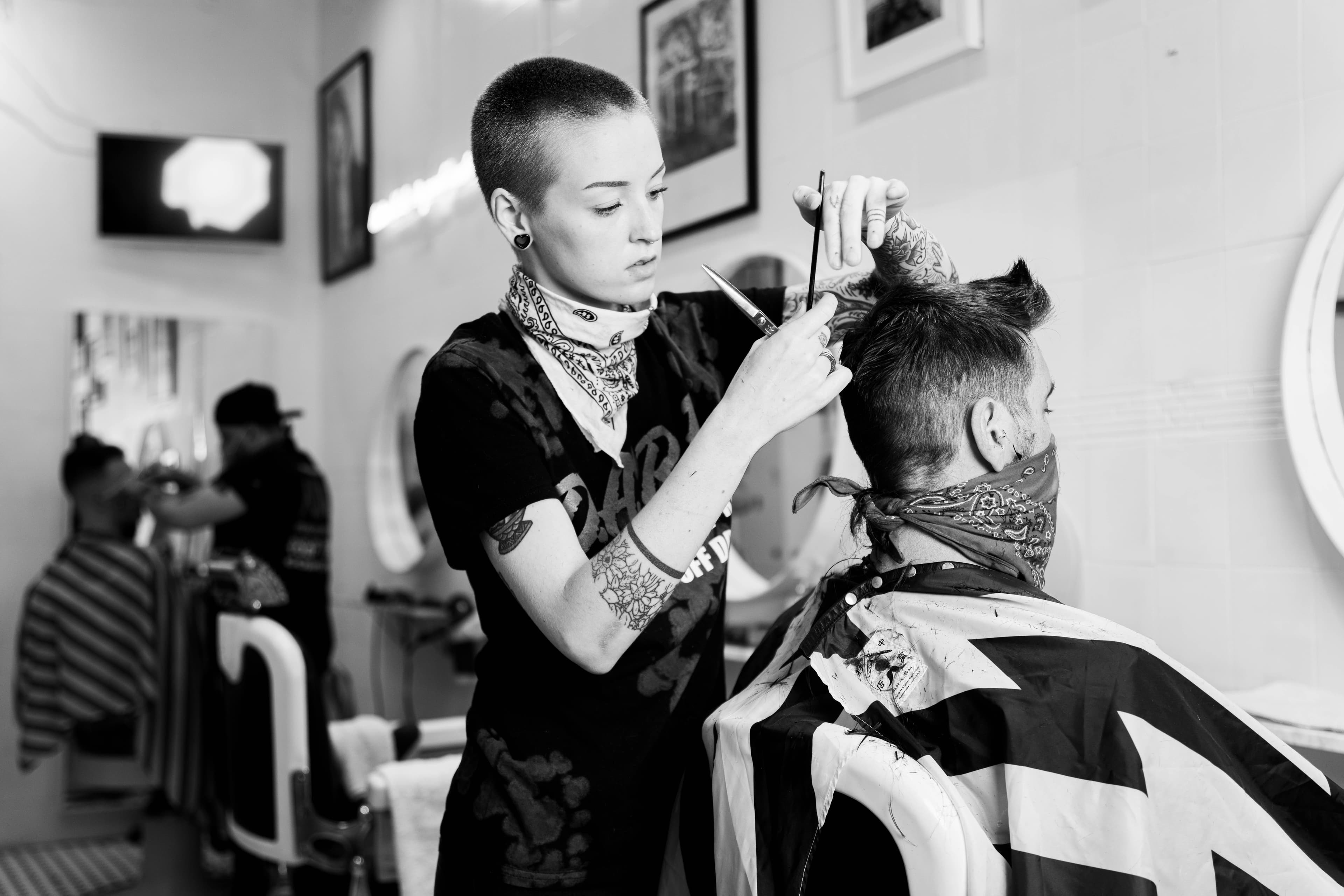 Black and white photograph of a barber cutting hair